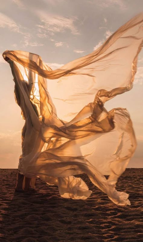 Vrouw op het strand in zonlicht met armen omhoog als beeld voor loslaten en je vrij voelen